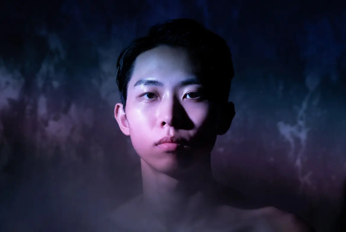 Moody adult portrait lit with purple and blue studio lighting